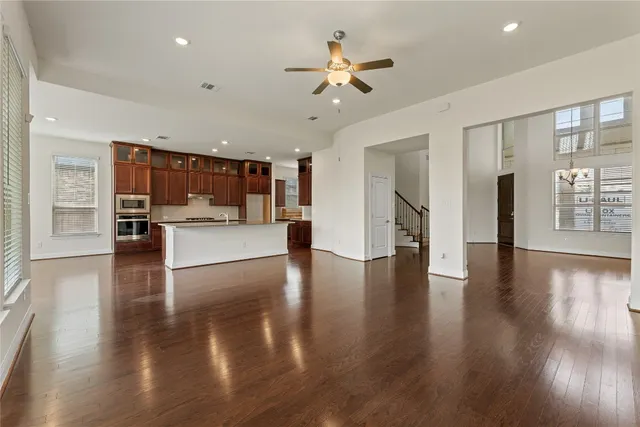a view of a big room with wooden floor and a kitchen