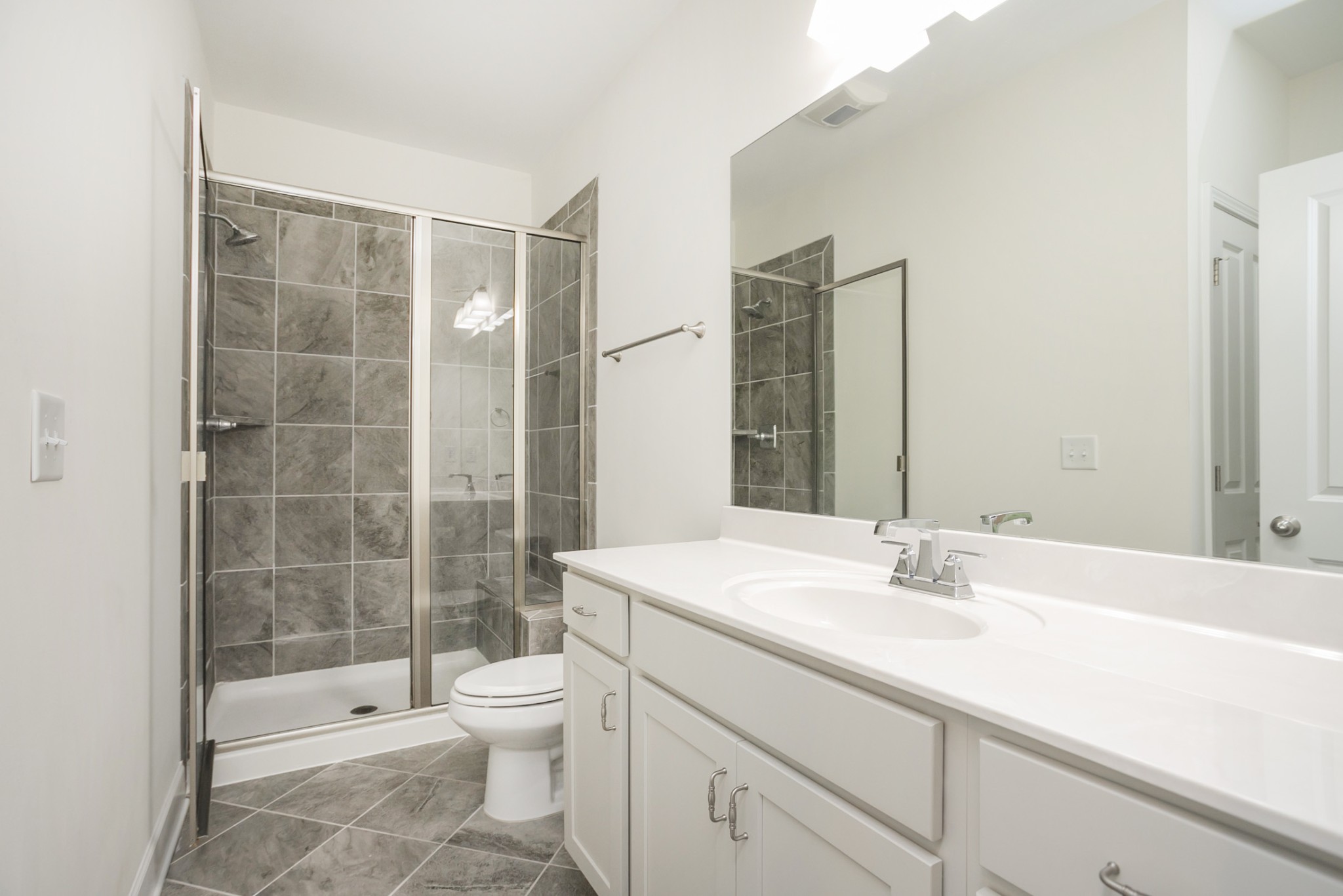145 Mary Ann Circle Spring Hill, TN 37174 - Photo 17 of 36 a bathroom with a shower sink vanity mirror and toilet