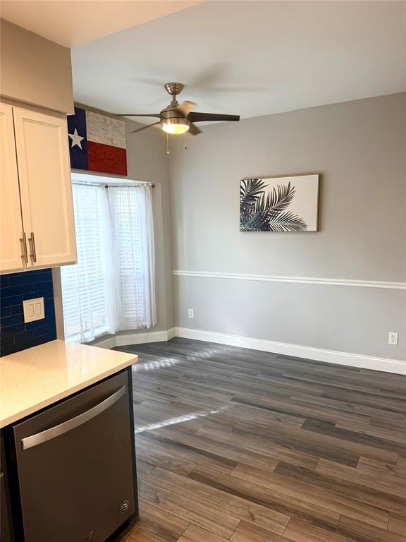14333 Preston Road, Unit 806 Dallas, TX 75254 - Photo 8 of 17 Wood-finish flooring throughout, bright window with blinds, ceiling fan with light fixture, built-in dishwasher, and white cabinetry with gold-tone hardware