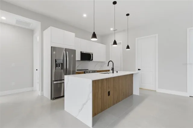 a kitchen with a sink a stove and chairs