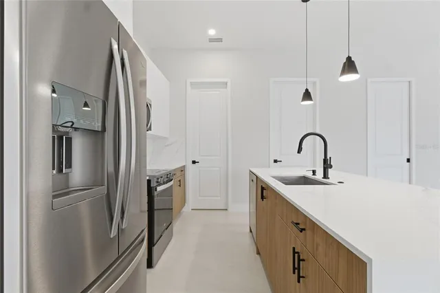 a kitchen with stainless steel appliances granite countertop a sink a stove and a refrigerator