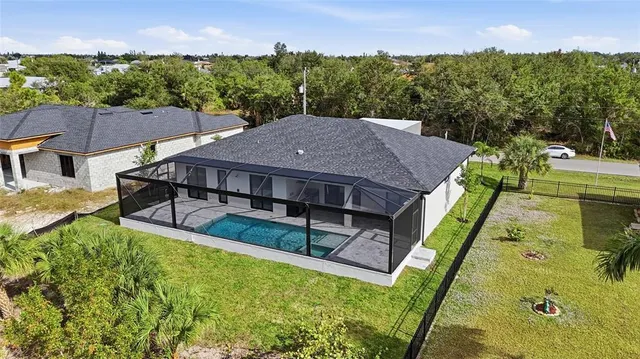 a view of a house with pool and a yard