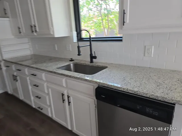 a kitchen with granite countertop a sink and a window