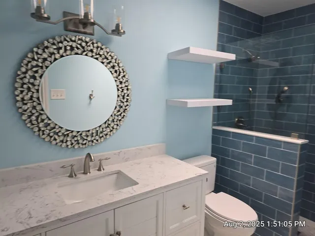 a bathroom with a toilet a sink and mirror