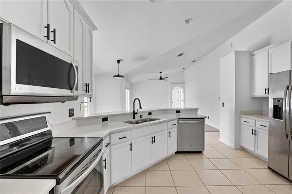a view of an empty room and kitchen