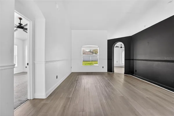 a view of a room with wooden floor and white walls