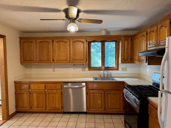 a kitchen with a sink stove top oven and cabinets