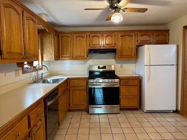 a kitchen with stainless steel appliances granite countertop a stove a refrigerator and a sink