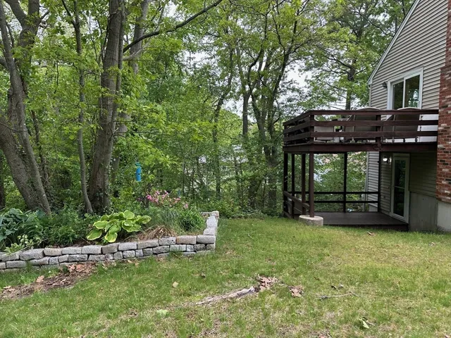 a view of a backyard with a table and chairs and a large tree