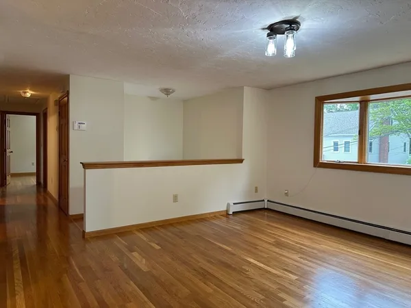 a view of a room with wooden floor and a window