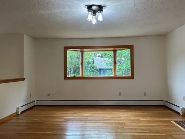 a view of a room with a window and wooden floor