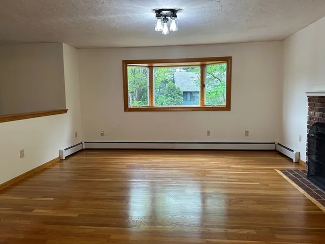 a view of a room with wooden floor and window