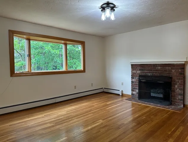 a view of an empty room with a fireplace and a window