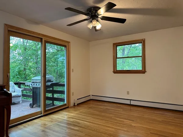 a view of an empty room with a window and wooden floor
