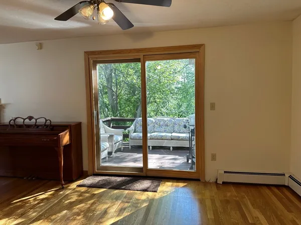 a view of a room with wooden floor and a floor to ceiling window