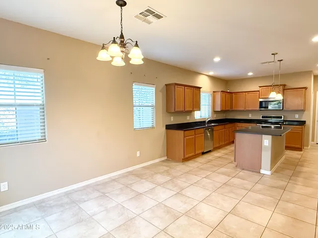 a kitchen with stainless steel appliances granite countertop a sink and a refrigerator
