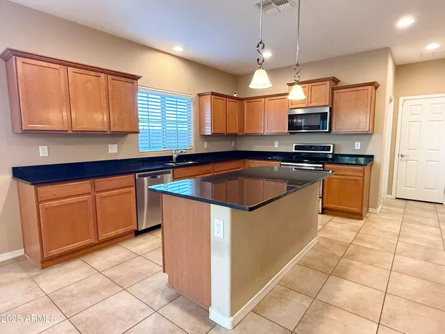 a kitchen with stainless steel appliances granite countertop a sink counter space cabinets and a window