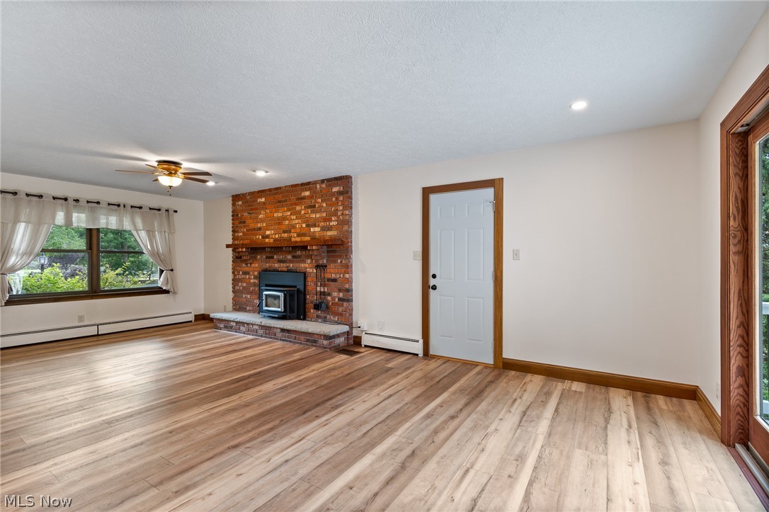 34 Kehner Road Mogadore, OH 44260 - Photo 7 of 40 Hardwood-finish flooring, brick fireplace with a stone hearth, recessed lighting, and a ceiling fan
