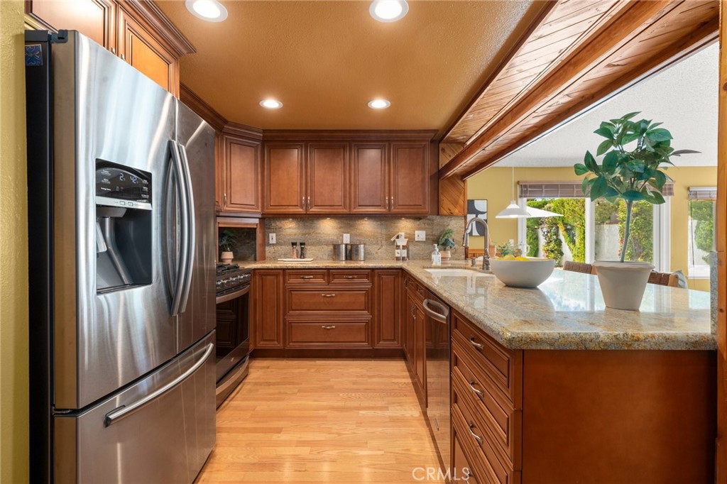 26017 Redbluff Drive Calabasas, CA 91302 - Photo 9 of 29 a kitchen with stainless steel appliances granite countertop a refrigerator a sink a stove and a wooden cabinets