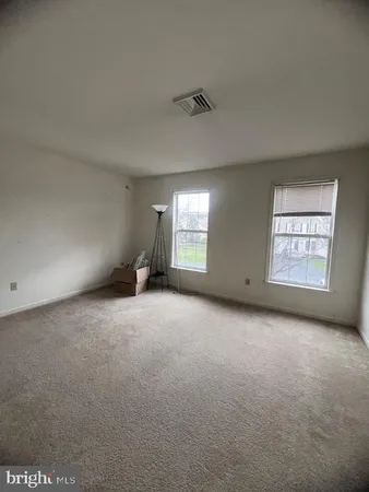 an empty room with a fireplace and windows