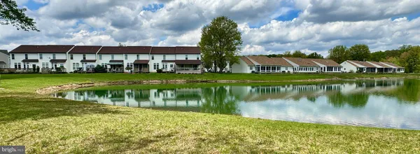 a view of a lake with a big yard and large trees