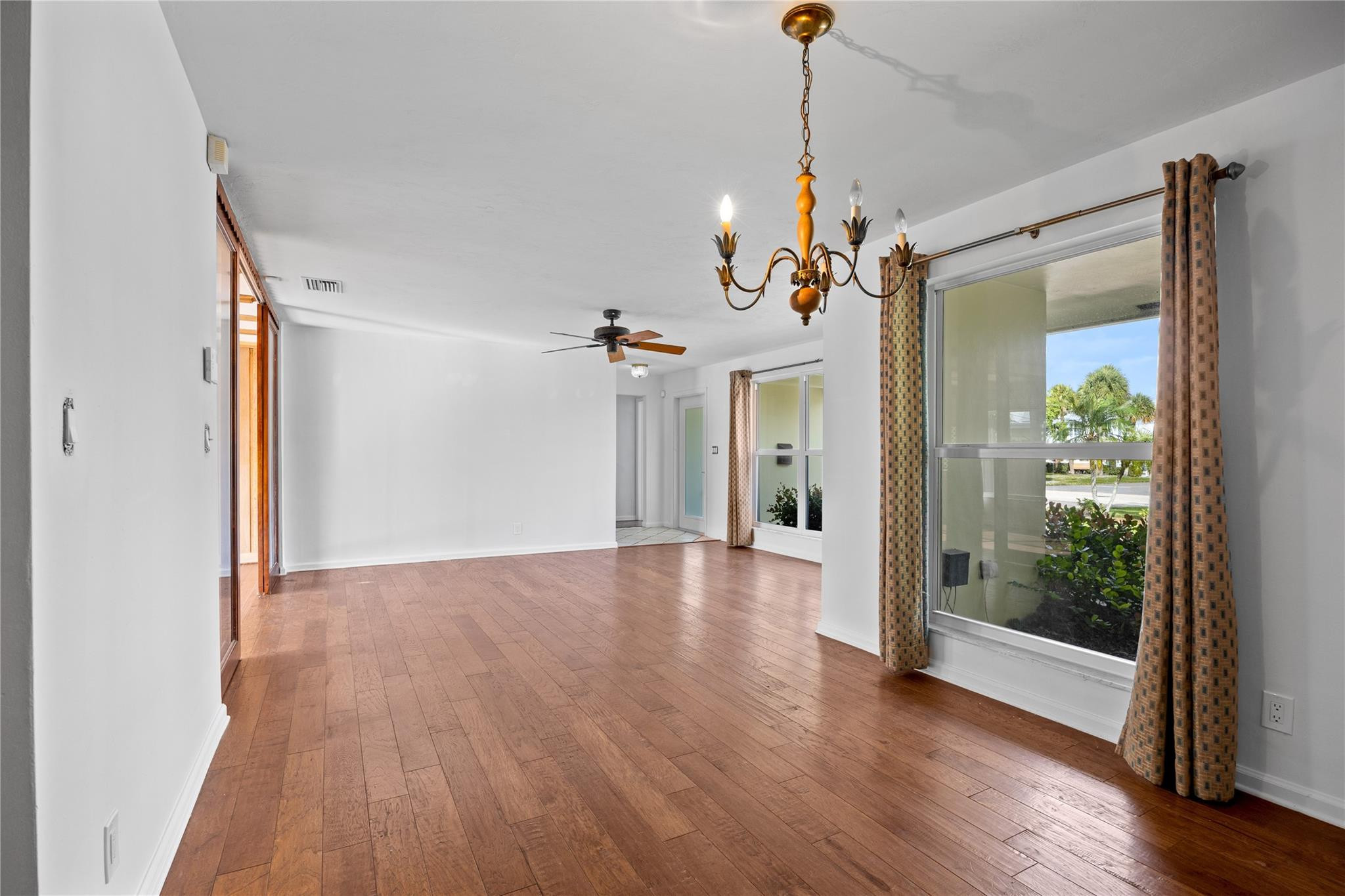 6543 Northeast 21st Road Fort Lauderdale, FL 33308 - Photo 16 of 38 a view of a room with wooden floor a ceiling fan and windows