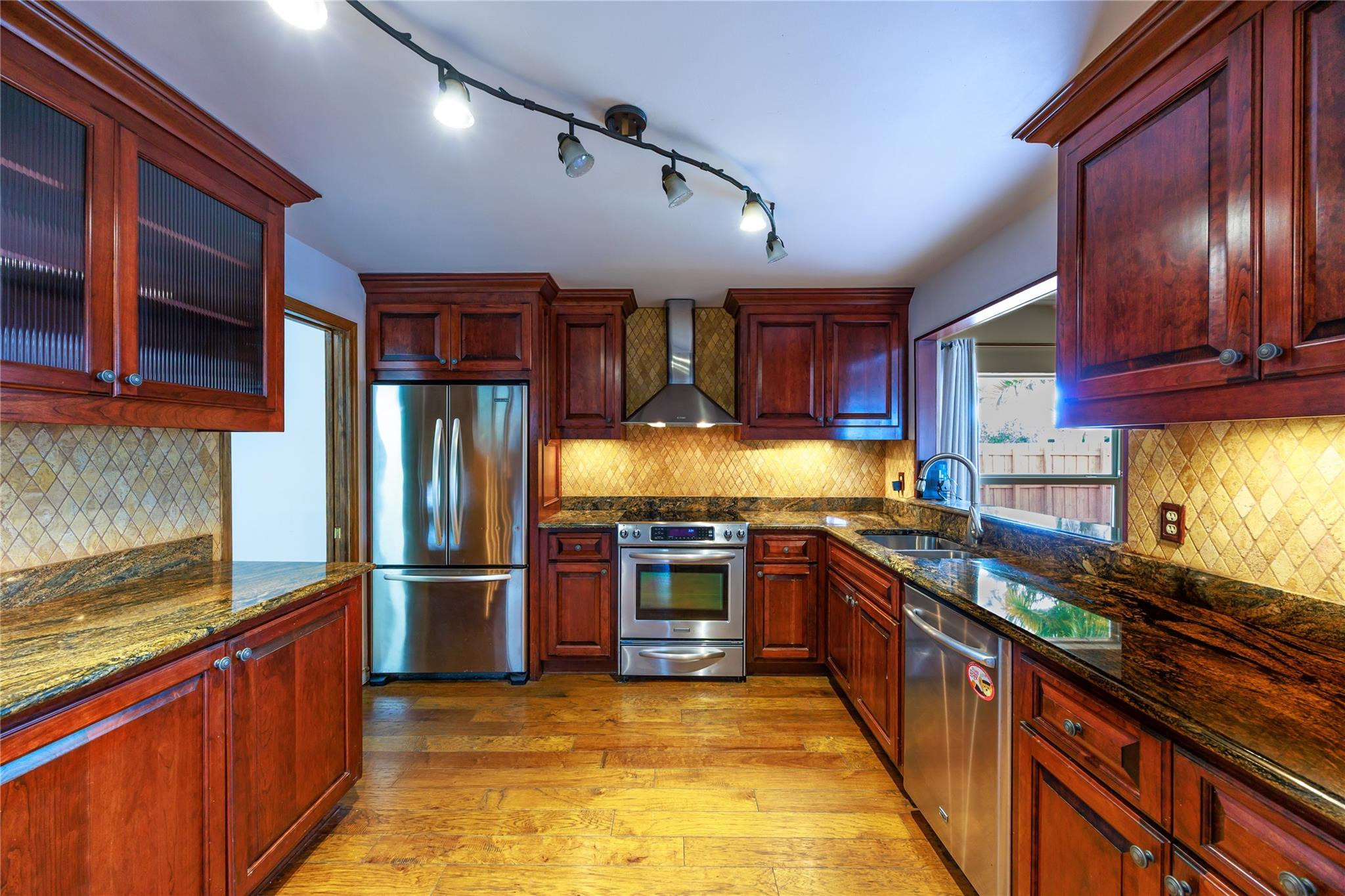 6543 Northeast 21st Road Fort Lauderdale, FL 33308 - Photo 18 of 38 a kitchen with stainless steel appliances granite countertop wooden cabinets a sink dishwasher a stove and a refrigerator