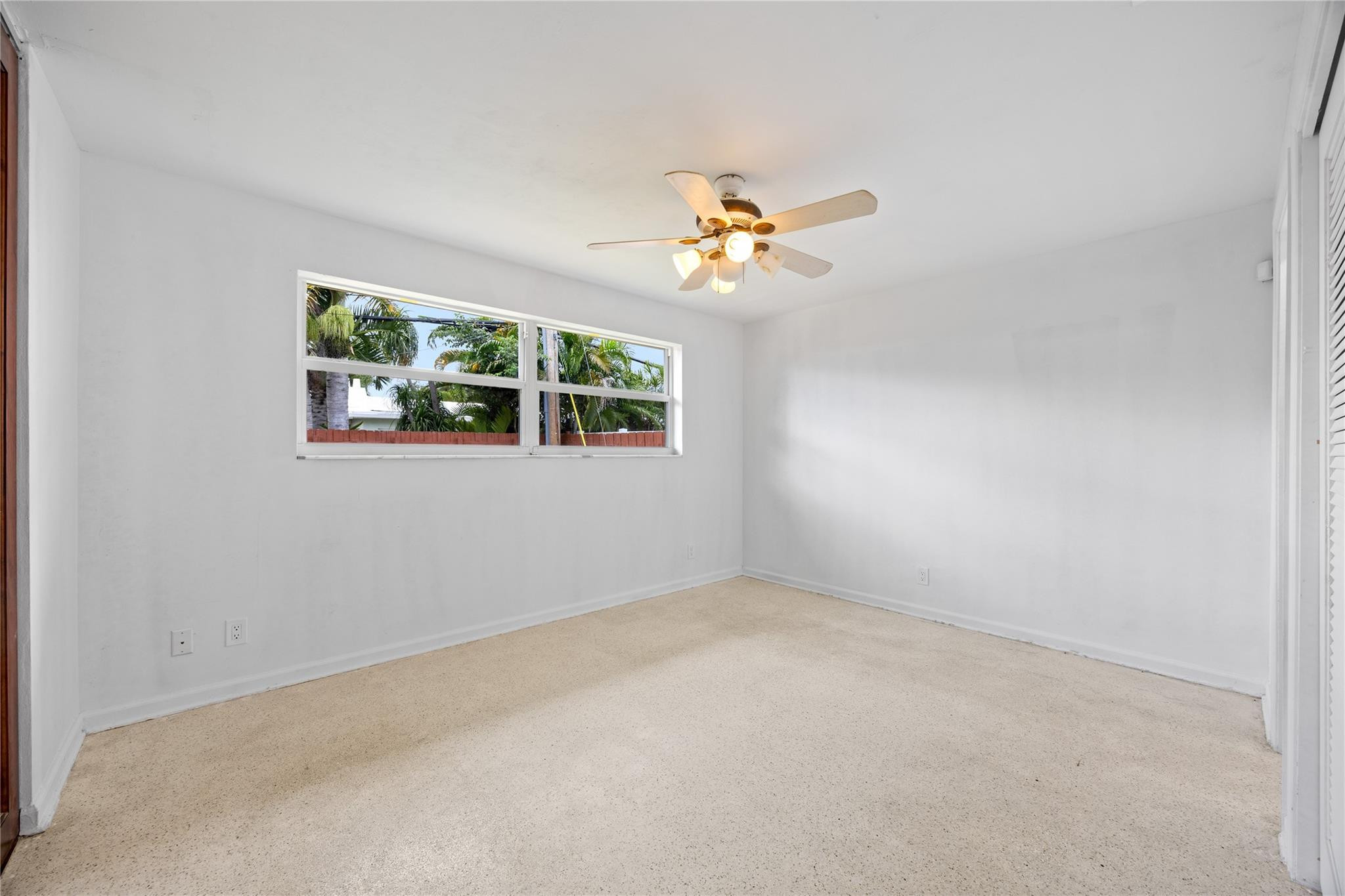 6543 Northeast 21st Road Fort Lauderdale, FL 33308 - Photo 29 of 38 an empty room with windows and a ceiling fan