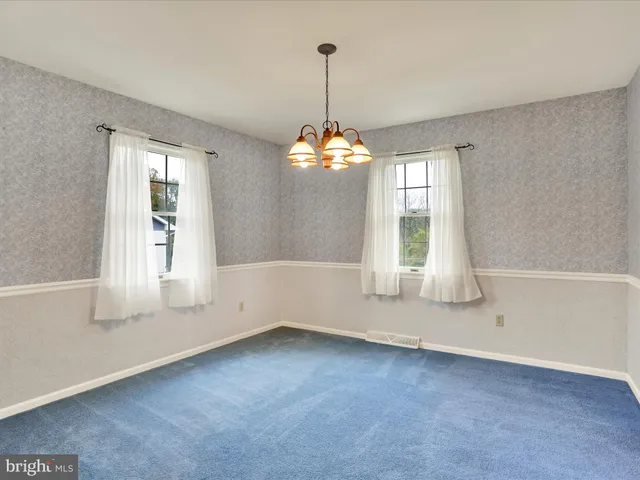 an empty room with windows and chandelier