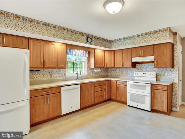 a kitchen with granite countertop a sink stainless steel appliances and cabinets