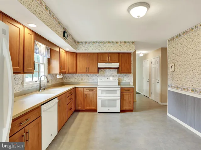 a large kitchen with stainless steel appliances granite countertop a lot of counter space and a sink