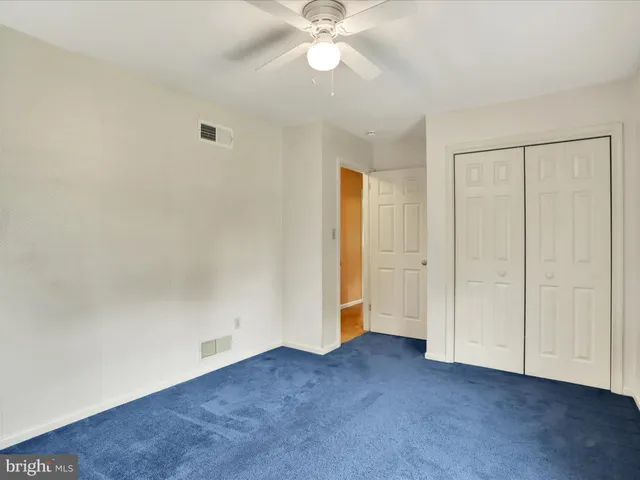 an empty room with closet and fan