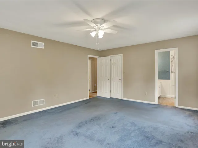 a view of an empty room with a ceiling fan