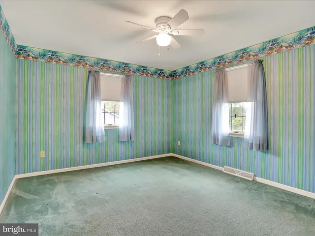 a view of a big room with windows and chandelier fan