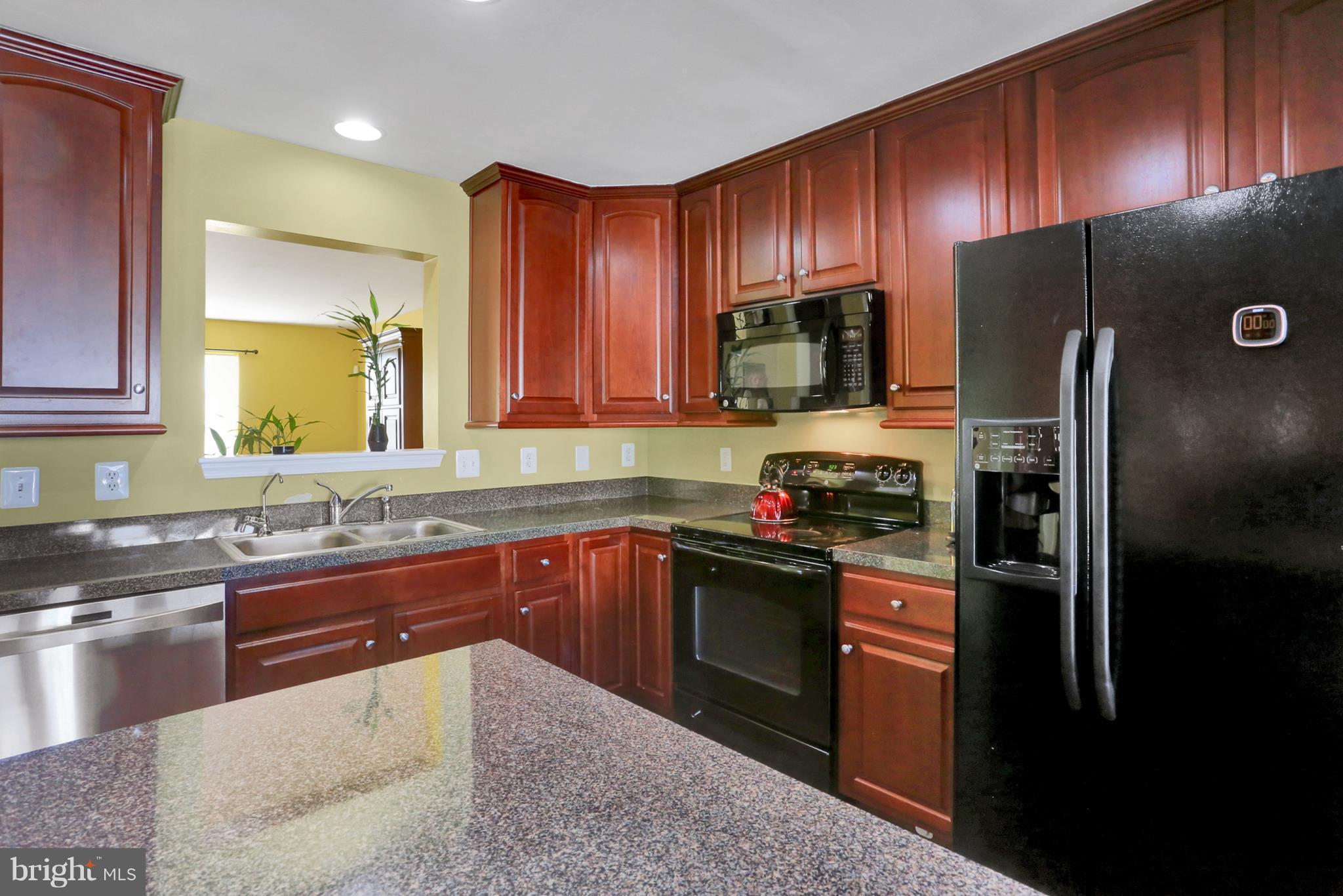 1219 Steed Street Ranson, WV 25438 - Photo 5 of 30 a kitchen with stainless steel appliances granite countertop wooden cabinets a stove a sink and a refrigerator