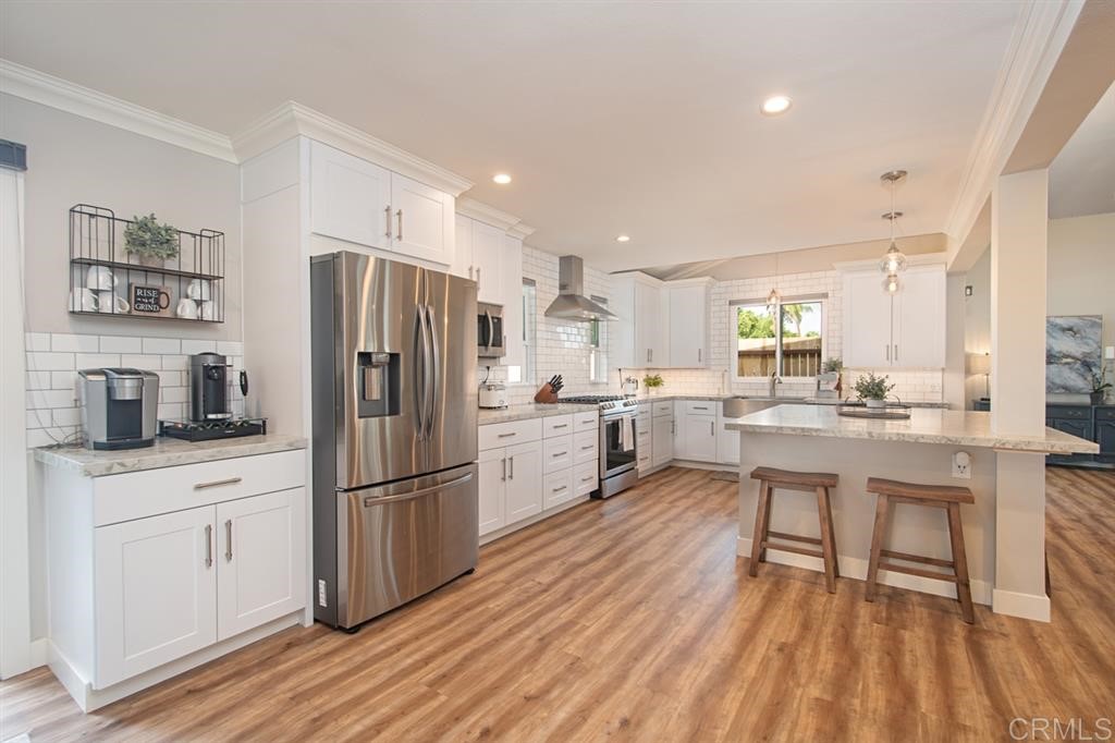 3701 Catalina Drive Carlsbad, CA 92010 - Photo 13 of 25 a kitchen with white cabinets and stainless steel appliances