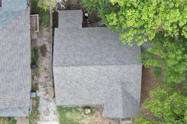 an aerial view of a house with a yard and large trees