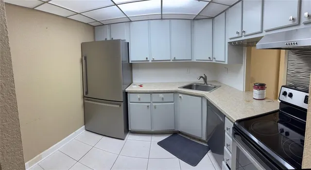 a kitchen with a refrigerator sink and cabinets
