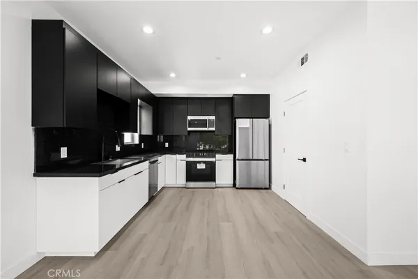 a kitchen with stainless steel appliances a refrigerator and a microwave