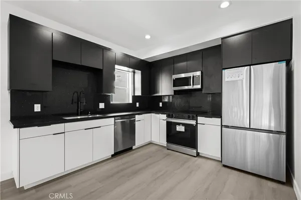 a kitchen with granite countertop a refrigerator and a sink