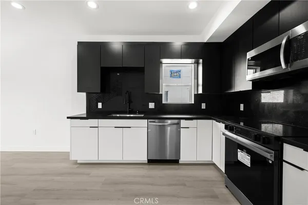 a kitchen with stainless steel appliances granite countertop a sink and a stove