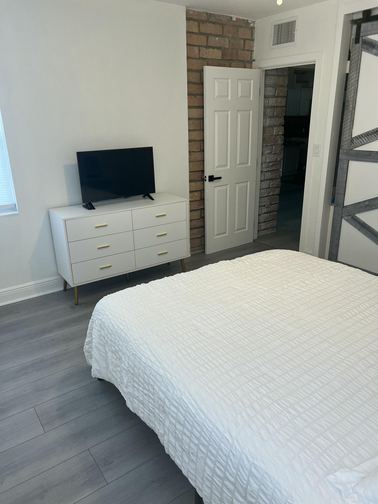 1016 Chipola Road, Unit B Fort Pierce, FL 34950 - Photo 13 of 17 a bedroom with a bed and a flat screen tv