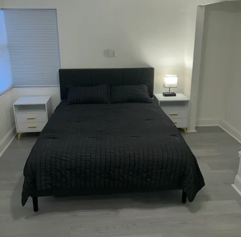 a bedroom with a bed and a night stand