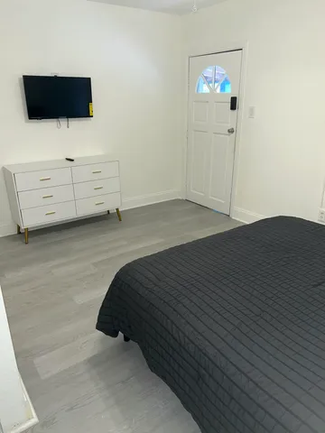 a bedroom with a bed and a flat screen tv