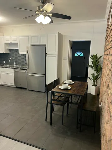 a kitchen with a table chairs refrigerator and microwave