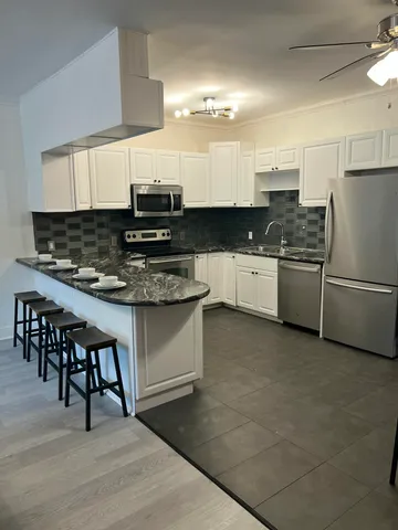 a kitchen with stainless steel appliances granite countertop a stove a sink dishwasher and a refrigerator