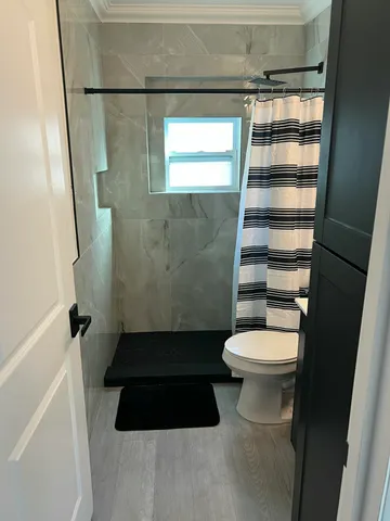 a bathroom with a toilet and a shower