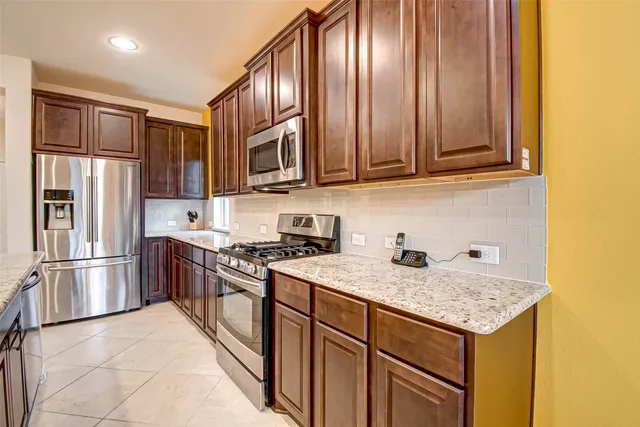 a kitchen with granite countertop cabinets stainless steel appliances and a counter