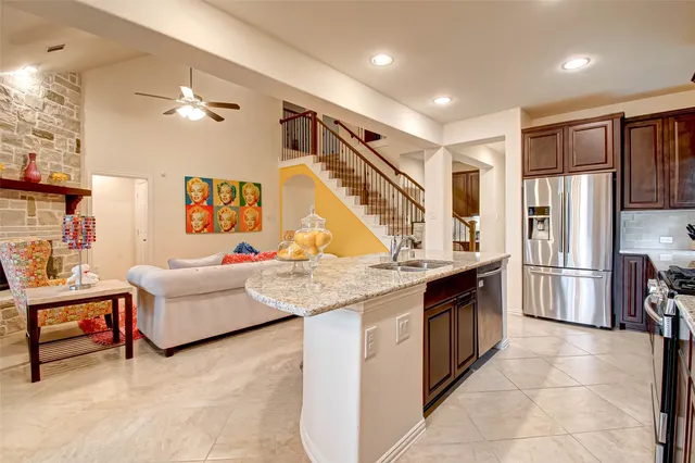 a living room with furniture and a refrigerator