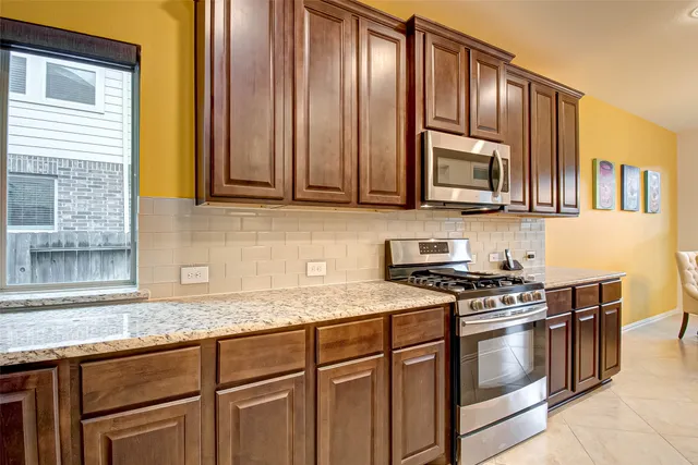 a kitchen with granite countertop cabinets stainless steel appliances and a sink